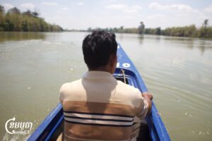 A resident of Thmey village in Ratanakiri province rides a boat along the Srepok River to visit the proposed Lower Srepok 3 dam site. March 14, 2025. (CamboJA/Coby Hobbs)