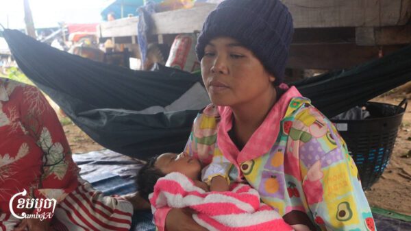 Chuon Lina, 36, nurses her one-month-old daughter at a displacement camp after fleeing clashes with Thai forces in Preah Vihear province. Dec. 10, 2025. (CamboJA/Coby Hobbs)